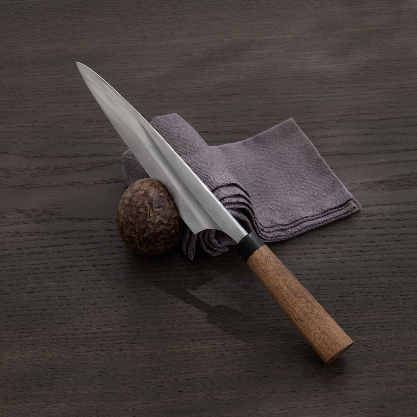 High carbon steel chef's knife resting on passion fruit.