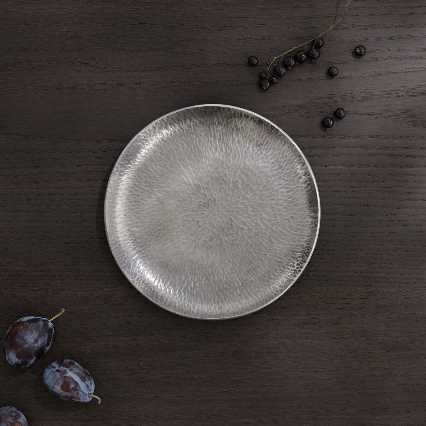 Tack hammer textured plate with black currants and plums.