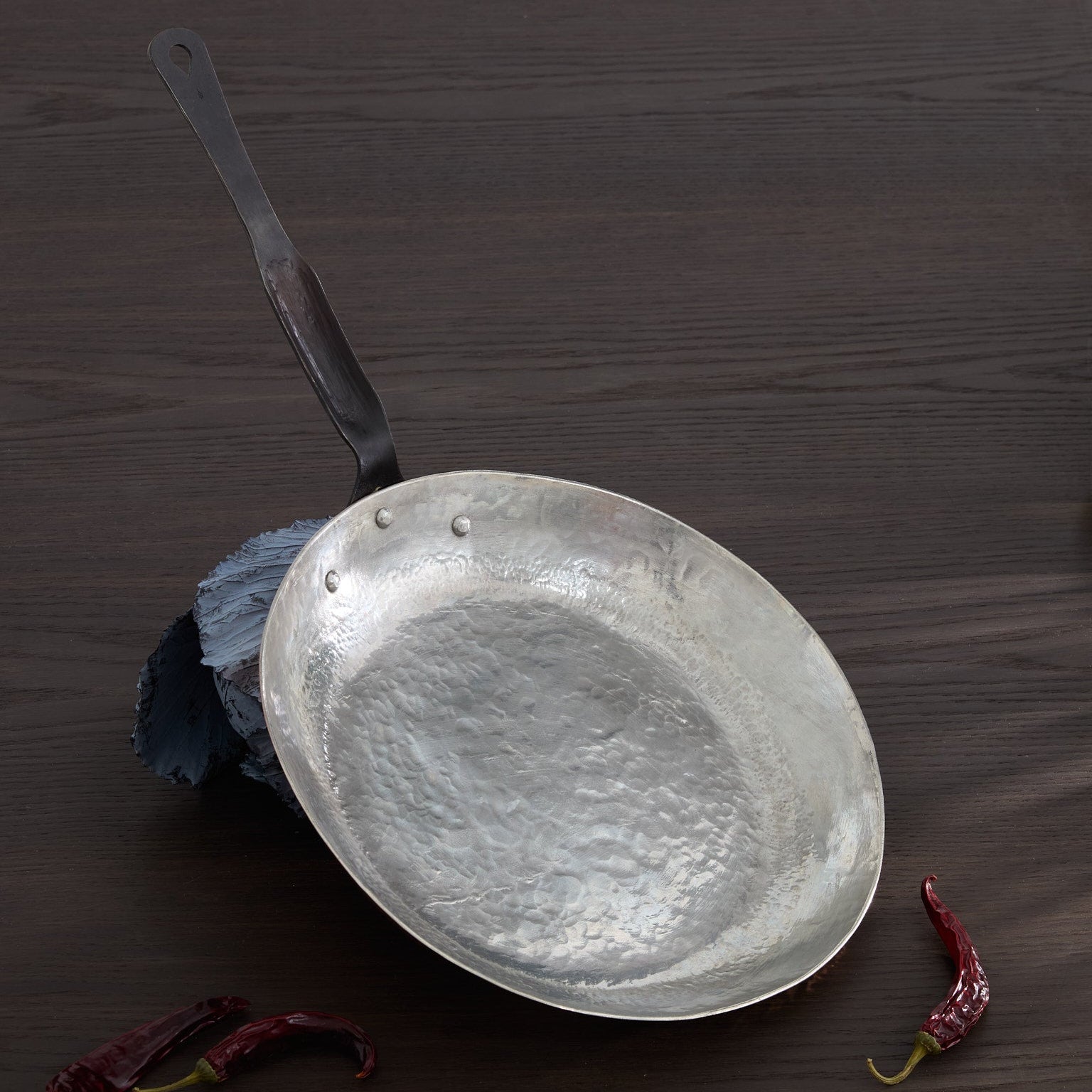 Hand raised copper pan resting on cabbage. 